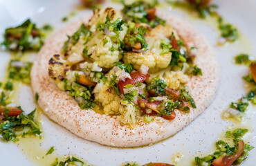 Tasty bean porridge with cauliflower and vegetables on white plate