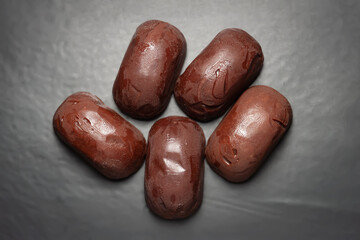Chocolate candies. Top view of melting chocolate candies on a dark