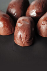 Chocolate candies. A bunch of melting chocolate candies on a black