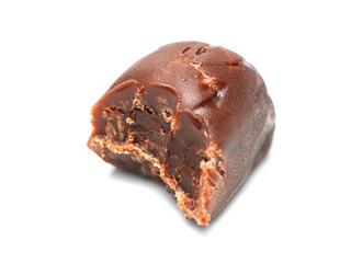 Chocolate candy. Close-up of a bitten chocolate candy on a white