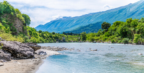 A view eastward down the Vjosa River towards a footbridge at Kelcyre, Albania in summertime