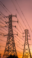 Electric towers lined up against a sunset