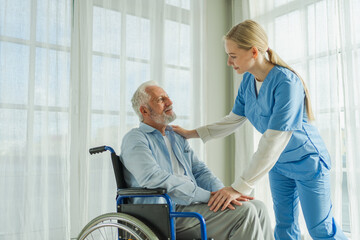 Help support retirement healthcare. Nurse helping old man in wheelchair. Patient and woman in...