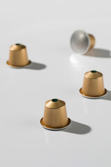 The golden coffee capsules on a white background, for advertising and commercial use.