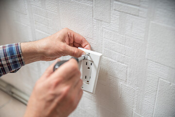 Installation or repair of electrical outlet socket box within the wall. Serviceman or repairman...