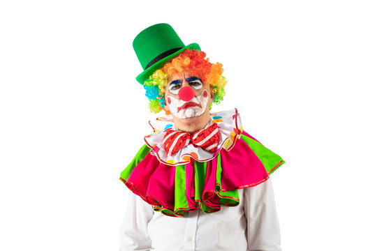 Portrait of creepy clown. Entertainer Joker in colorful suit and wig. Buffoon with clown whiteface makeup. Trickster, jester, pantomime, mime.