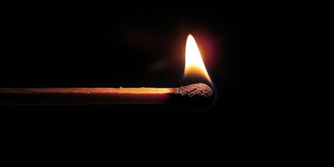 A single matchstick burning brightly in the dark, symbol of hope and resilience against life's challenges