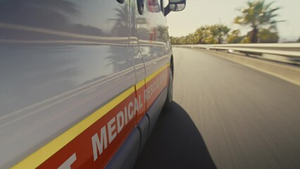 An ambulance driving fast on a highway