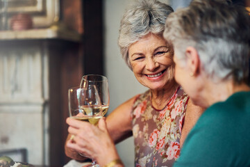 Senior women, wine and relax with toast for retirement celebration, communication with happiness in house. Elderly, female people and alcohol drink in home with conversation, cheers for wellness