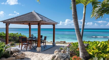 A beach scene with a wooden gazebo and a table with chairs. The gazebo is surrounded by a rock wall and there are several potted plants nearby. The atmosphere is relaxed and inviting