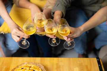 Close up hand holding glass. Group of young asian people smiling friends drinking at birthday party toast with beer. food and beverag
