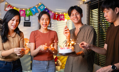 group of friends having fun with sparklers dancing confetti. celebrating Birthday party. Group of friends smiling enjoying party