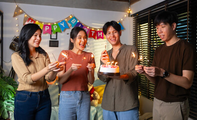 group of friends having fun with sparklers dancing confetti. celebrating Birthday party. Group of friends smiling enjoying party