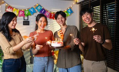 group of friends having fun with sparklers dancing confetti. celebrating Birthday party. Group of friends smiling enjoying party