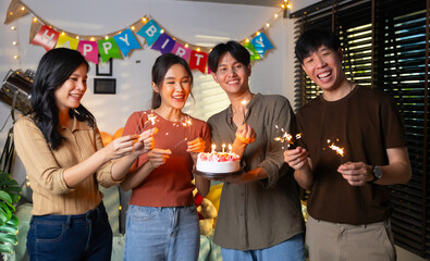 group of friends having fun with sparklers dancing confetti. celebrating Birthday party. Group of friends smiling enjoying party