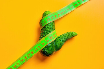 Cucumber with Tape Measure Isolated on Yellow