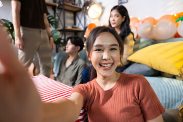 Selfie photo. Happy smile diverse friends enjoying time together and making selfie photo by mobile phone at home party. Group of asian people friends in birthday party at home