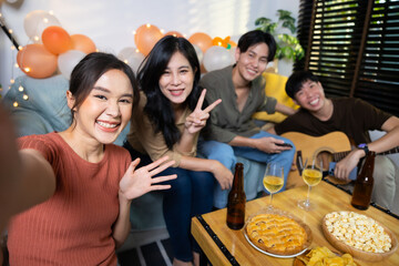 Selfie photo. Happy smile diverse friends enjoying time together and making selfie photo by mobile phone at home party. Group of asian people friends in birthday party at home