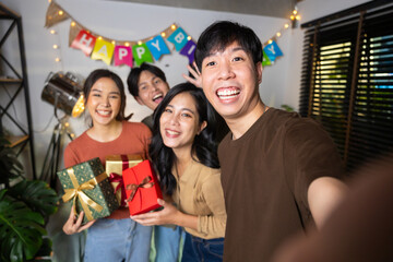 Selfie photo. Happy smile diverse friends enjoying time together and making selfie photo by mobile phone at home party. Group of asian people friends in birthday party at home
