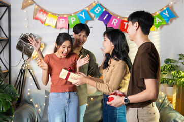 Surprise Friends give birthday gifts to friends at her birthday party. celebrating Birthday party. Group of friends smiling enjoying party