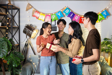 Surprise Friends give birthday gifts to friends at her birthday party. celebrating Birthday party. Group of friends smiling enjoying party