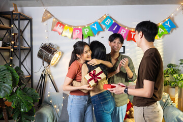 Surprise Friends give birthday gifts to friends at her birthday party. celebrating Birthday party. Group of friends smiling enjoying party