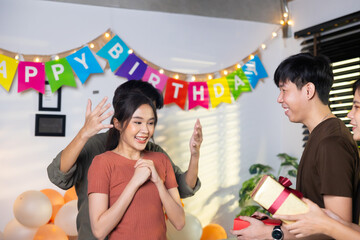 Surprise Friends give birthday gifts to friends at her birthday party. celebrating Birthday party. Group of friends smiling enjoying party