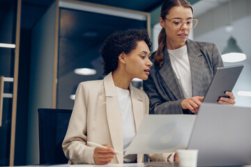 Two female professional executives experts discussing financial accounting papers working together
