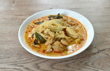spicy boiled slice pickled bamboo shoot with chicken in coconut milk curry soup on plate 