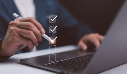 Business performance checklist, businessman using laptop doing online checklist survey, filling out...