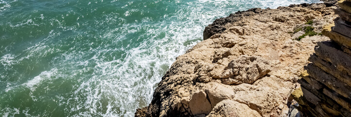 Rugged coastline with foamy waves crashing against rocky cliffs, ideal for travel and nature themes, related to summer, adventure tourism, and coastal preservation