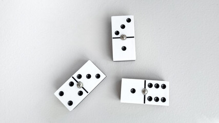 Three strategically placed white dominoes with black dots on a grey background symbolize strategy and decision-making, perfect for business or game-related concepts