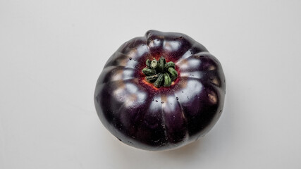 Fresh heirloom tomato on a white background, ideal for organic food and vegetarian diet concepts, not related to any specific holidays or ethnicity