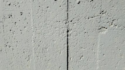 Textured gray concrete wall with visible crack, suitable for background graphics, urban decay themes, or construction-related concepts