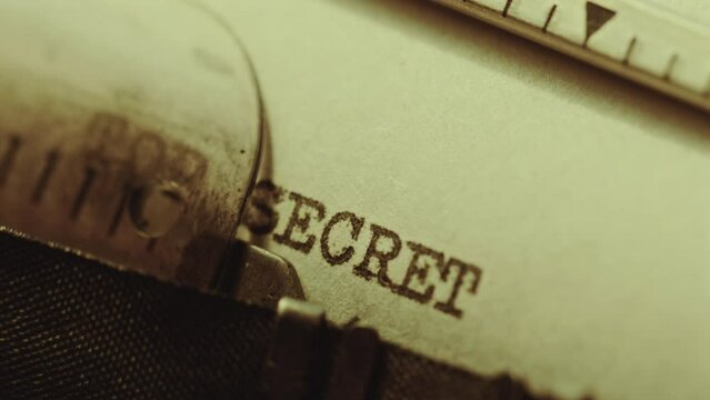 Writing Top Secret phrase in capital letters on paper with analog typewriter when working on document needed for security clearance. Extreme close-up view