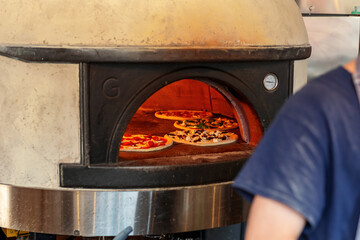 Italian pizza is cooked in a wood-fired oven