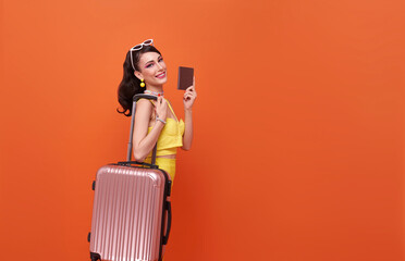 Happy smiling young tourist woman with luggage holding passport going to travel on holidays...