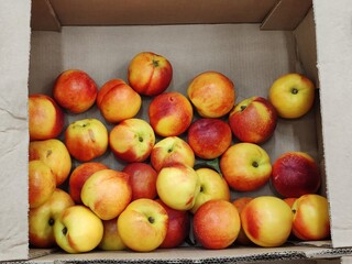 A box of peaches is sitting on a table