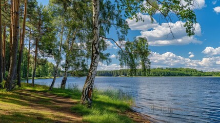 Obraz premium a beautiful forest lake surrounded by tall trees, with a clear blue sky and calm water, showing the shore and distant hills covered in pine forests.