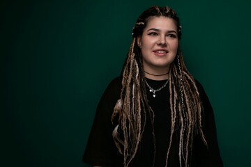 Woman With Dreadlocks Standing in Front of Green Background