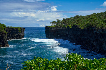 Black volcanic cliffs with big waves at O Le Pupu Pue lava fields in Samoa