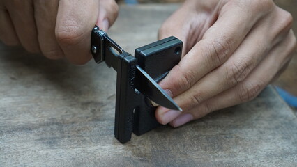 Man hands sharpening survival knife 
