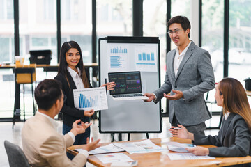 Professional diverse business team presenting and discussing data charts and graphs during meeting in modern office.