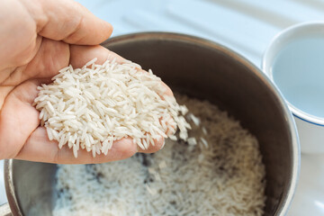 Woman rinsing rice under running water, closeup