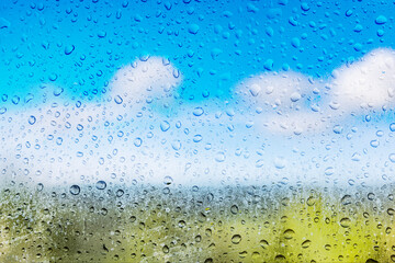 Regentropfen vor unscharfer Landschaft