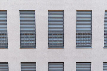 white house wall with uniform windows and blinds