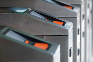Modern turnstiles at transportation hub. These electronic barriers control access and ensure security, allowing entry only to authorized individuals. Photo taken with shallow depth of field