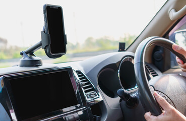 Cellphone on phone holder at car dashboard in car on travel road. Navigation auto location system application.