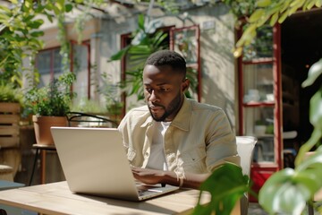 Obraz premium Successful African American Freelancer in Cafe Summer Terrace Video Conference.