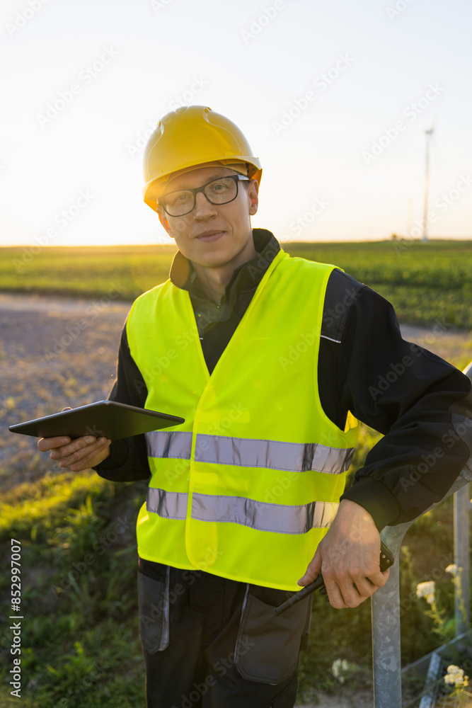 Aufkleber engineer with digital tablet works on a field of wind turbines
